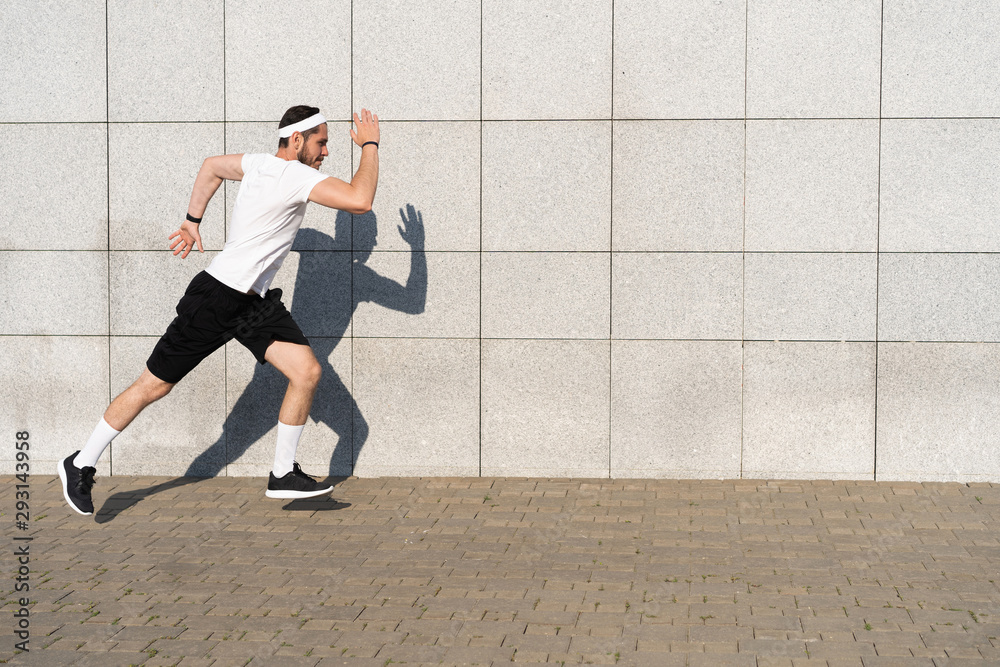 Fototapeta premium Handsome man running in the city. Fitness, workout, sport, lifestyle concept.