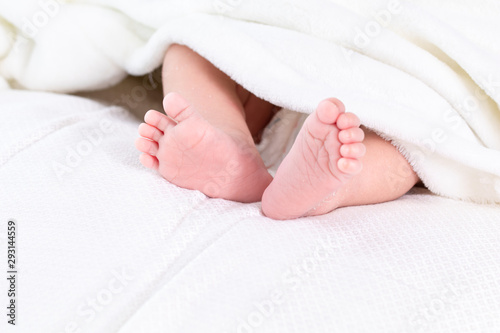 Selective focus 0-1 month newborn bare feet with tiny finger wrap by blanket or scarf