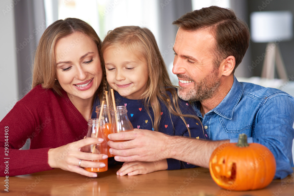 Family with pumpkin smoothie making a toast to halloween Family with pumpkin smoothie making a toast to halloween