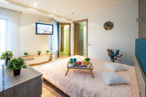 Interior of bedroom. Modern apartment. King-size bed. Tray with food. photo