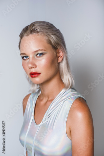 Attractive young blonde in a holographic silver hoody bodysuit.