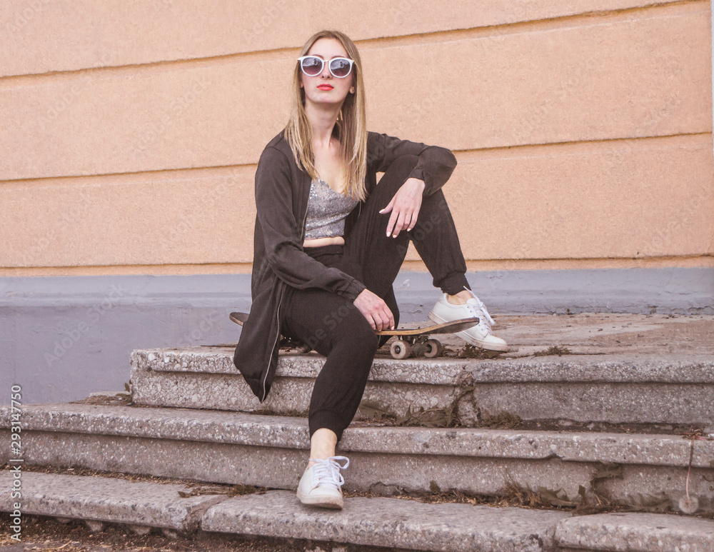 fashion woman sitting on skateboard. Girl in sunglasses with longboard on stairs fashion woman sitting on skateboard. Girl in sunglasses with longboard on stairs