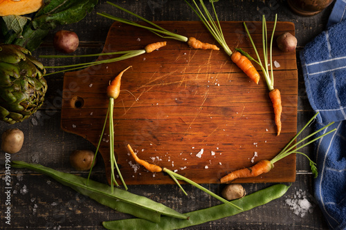 wooden table with baby carrots in circle for titles. background