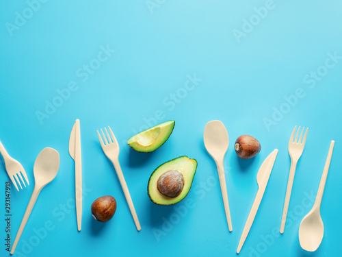 Avocado Seeds Biodegradable Single-Use Cutlery. Bioplastic - Great alternative to plastic disposable cutlery. Minimal concept on blue background. Copy space for text or design photo