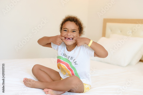 Cute little girl in pajamas on the bed in the morning