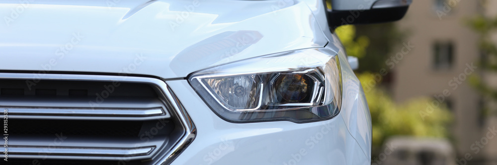 Focus on front of big fashionable jeep car. Automobile used for daily trips parked on road in residential area. Nice sport utility vehicle. Blurred background