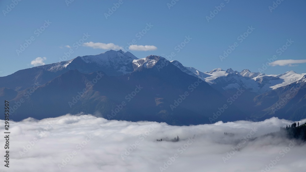 view to the alps on a sunny day with fog in the valley