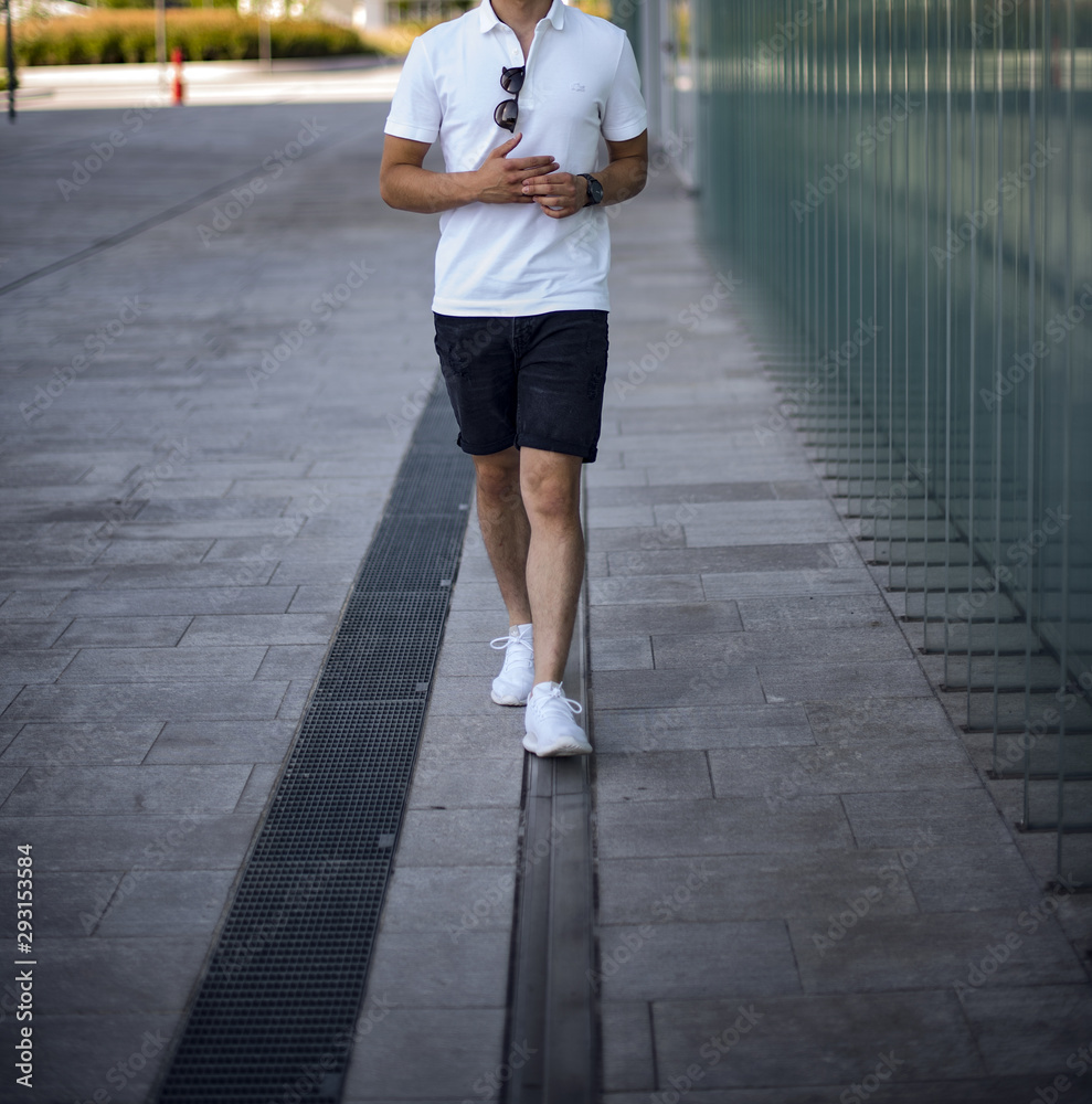 Young man wearing a pair of Nike Air Force One walking in the street Stock  Photo | Adobe Stock