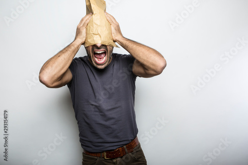 Uomo con busta di carta in testa photo