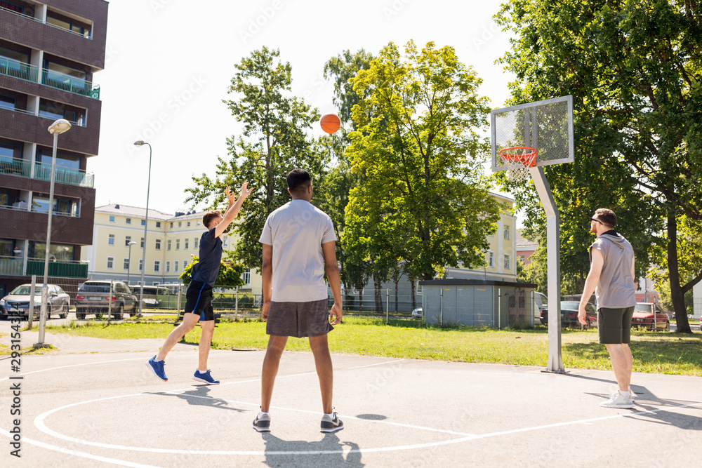 sport, leisure games and male friendship concept - group of men or friends playing street basketball