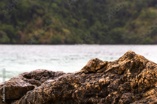 Rock on beach sea and mountain background