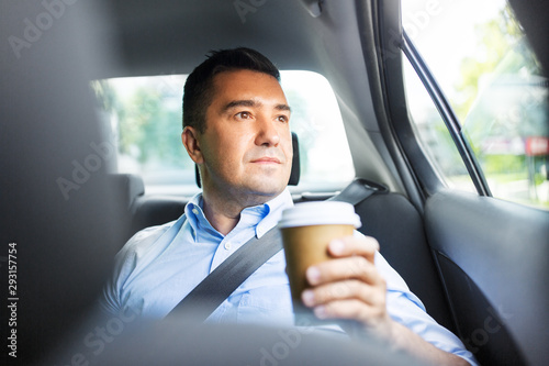 transport, business and people concept - businessman drinking takeaway coffee on back seat of taxi car © Syda Productions