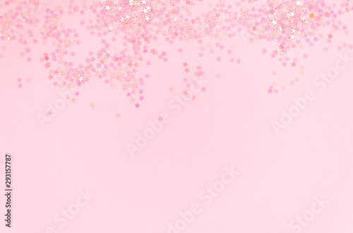 Pink glitter stars confetti frame with copy space on a pink background