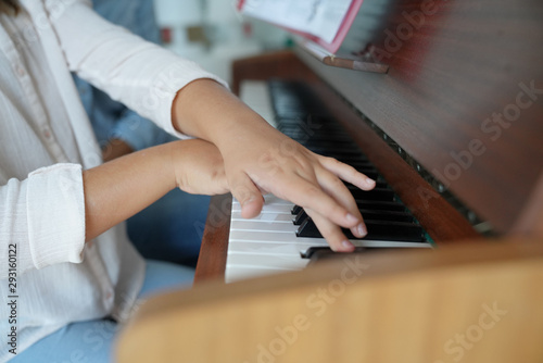 Closeup of child's hands playing the piano