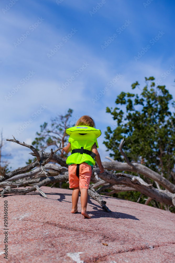 Kind mit Rettungsweste erkundet Insel. Child with lifejacket explore Island.