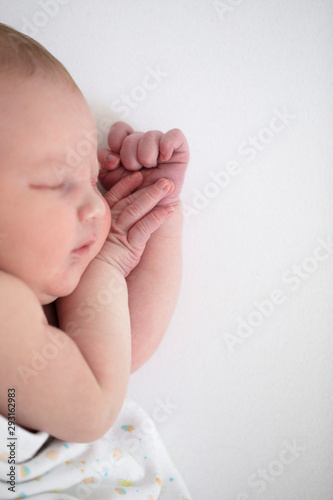 Close up of a cute sleeping baby resting on their arms