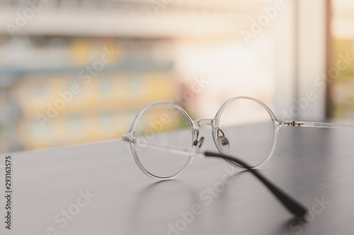 Soft focus of glasses on wooden table with windows. Lens flair in sunlight.