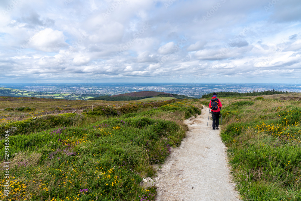 Lanscape of Wicklow way with a girl in the way and Dublin in the background.