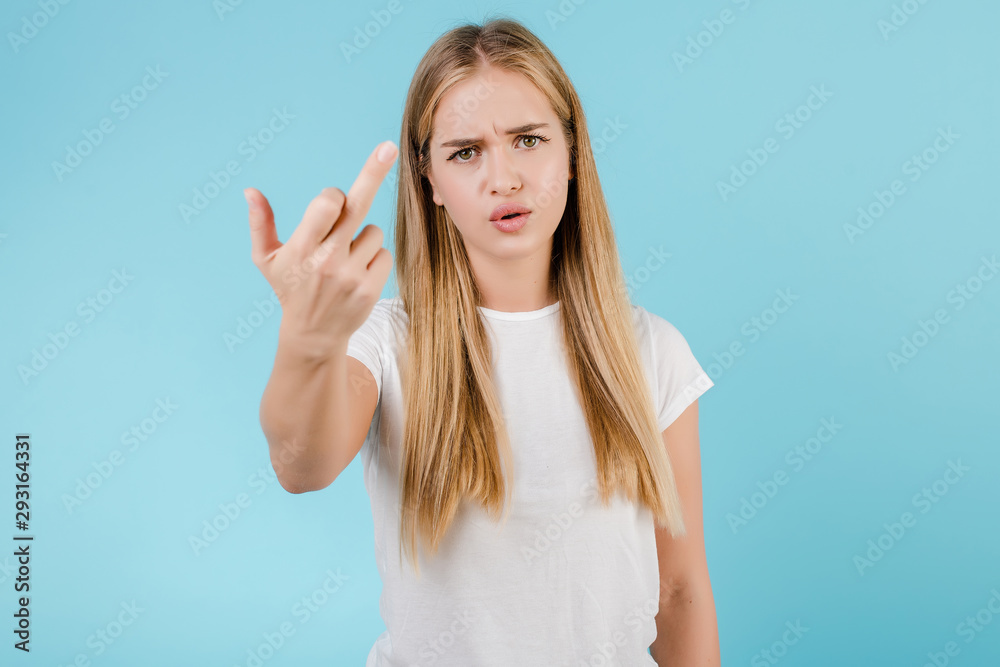 angry young woman showing middle finger isolated over blue angry young woman showing middle finger isolated over blue