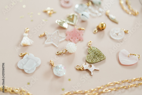 Fotografija Girls charm bracelet and necklace with scattered charms, pink background, christ