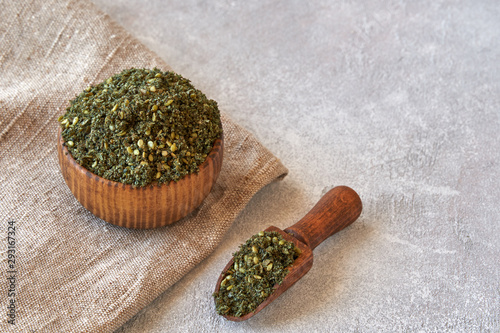 Mixed spice zaatar or zatar in wooden bowl on stone background photo