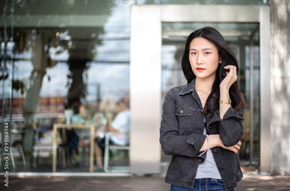 Successful young business woman standing in front of her own business office. Concept of the start-up business Successful young business woman standing in front of her own business office. Concept of the start-up business