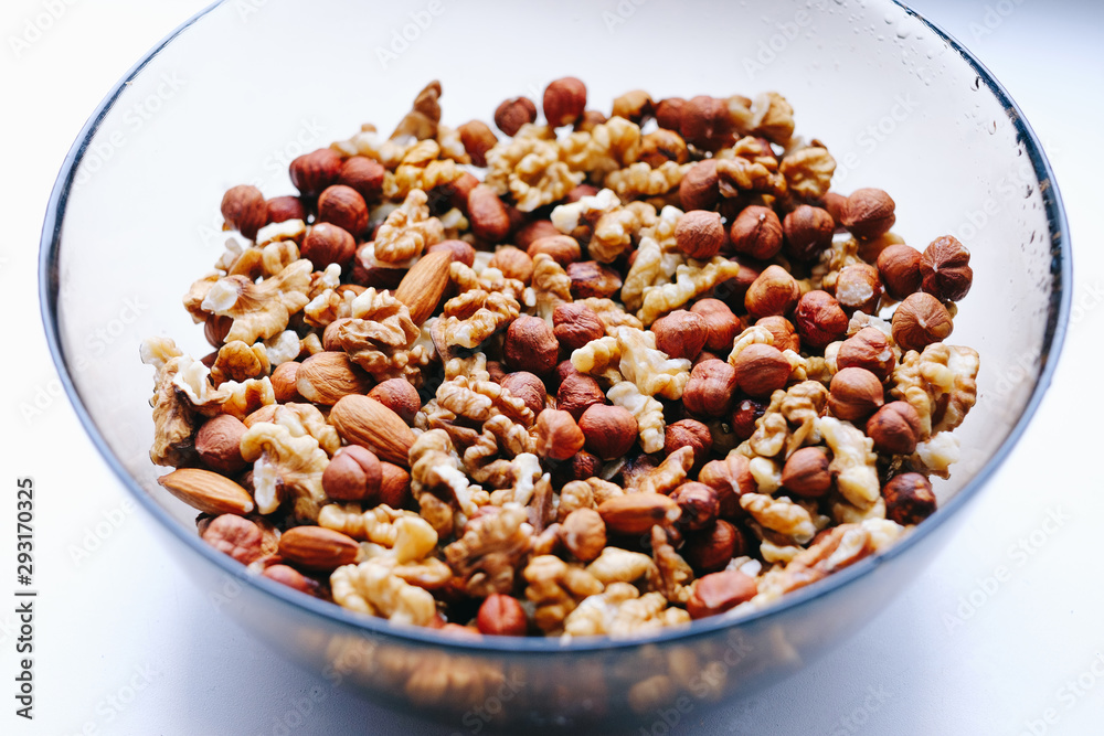 Glass plate with nuts on a white background, top view. Glass plate with nuts on a white background, top view.