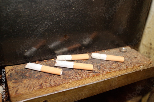 cigarette butts on a shelf in the toilet