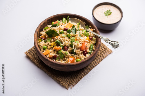 Broken wheat or Daliya Upma, served in a bowl. selective focus