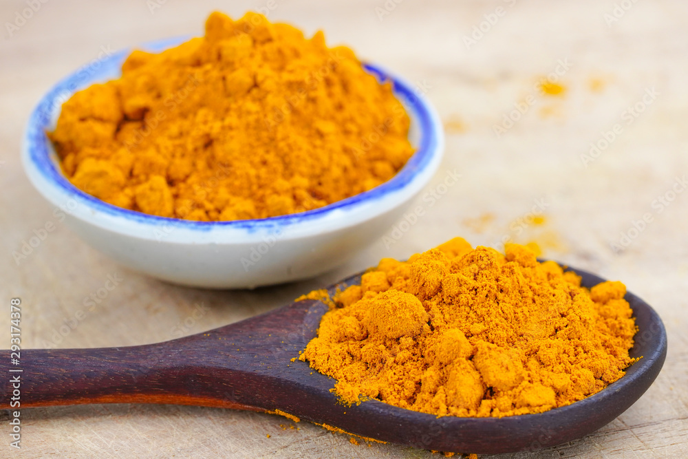 Turmeric roots and powder herb on wooden background. Turmeric roots and powder herb on wooden background.