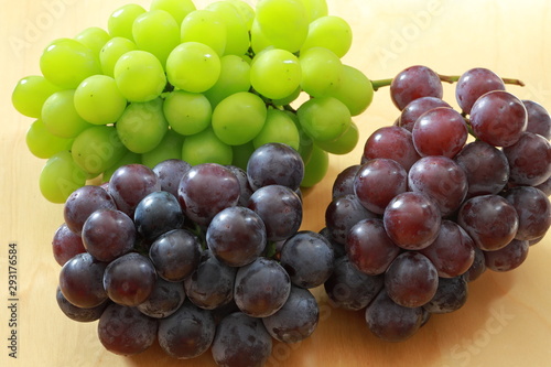 Green grapes and black grapes on the rable photo