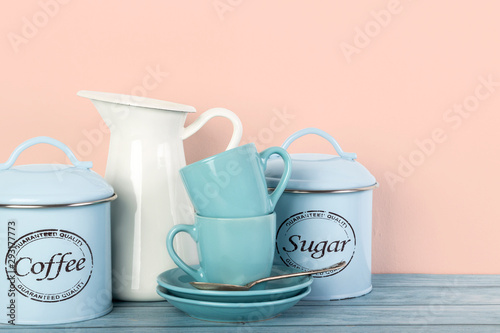 Coffee mugs, coffee and sugar jars and milk pitcher on kitchen shelf