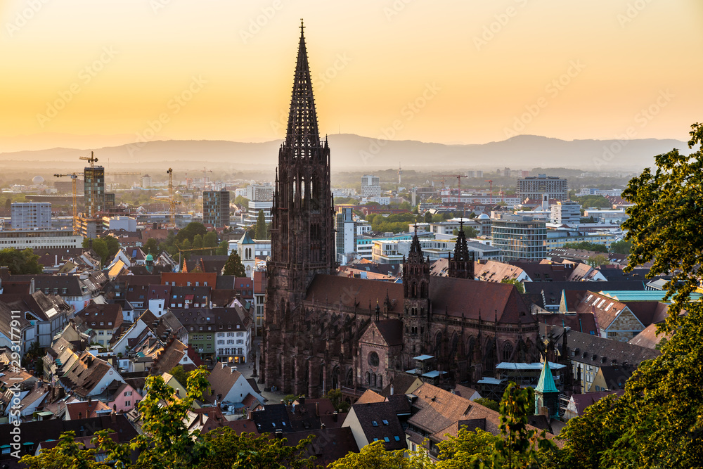 Germany, Black forest city freiburg im breisgau in baden in fantastic sunset twilight atmosphere, aerial view on muenster church from above the houses