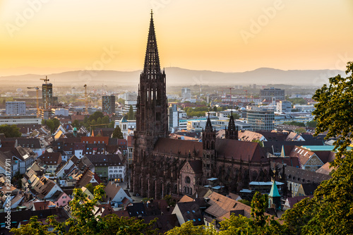 Germany, Black forest city freiburg im breisgau in baden in fantastic sunset twilight atmosphere, aerial view on muenster church from above the houses