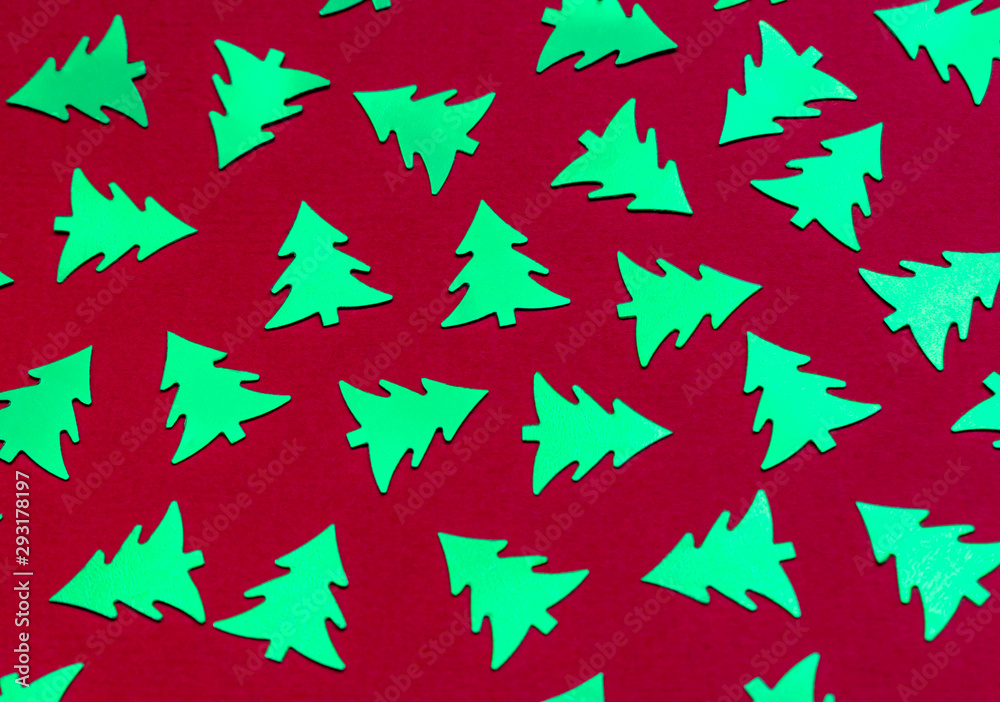 Metallic Christmas trees on a trendy red background. Bright abstract new year's concept. Shiny decorative elements pattern. Top view. Metallic Christmas trees on a trendy red background. Bright abstract new year's concept. Shiny decorative elements pattern. Top view.