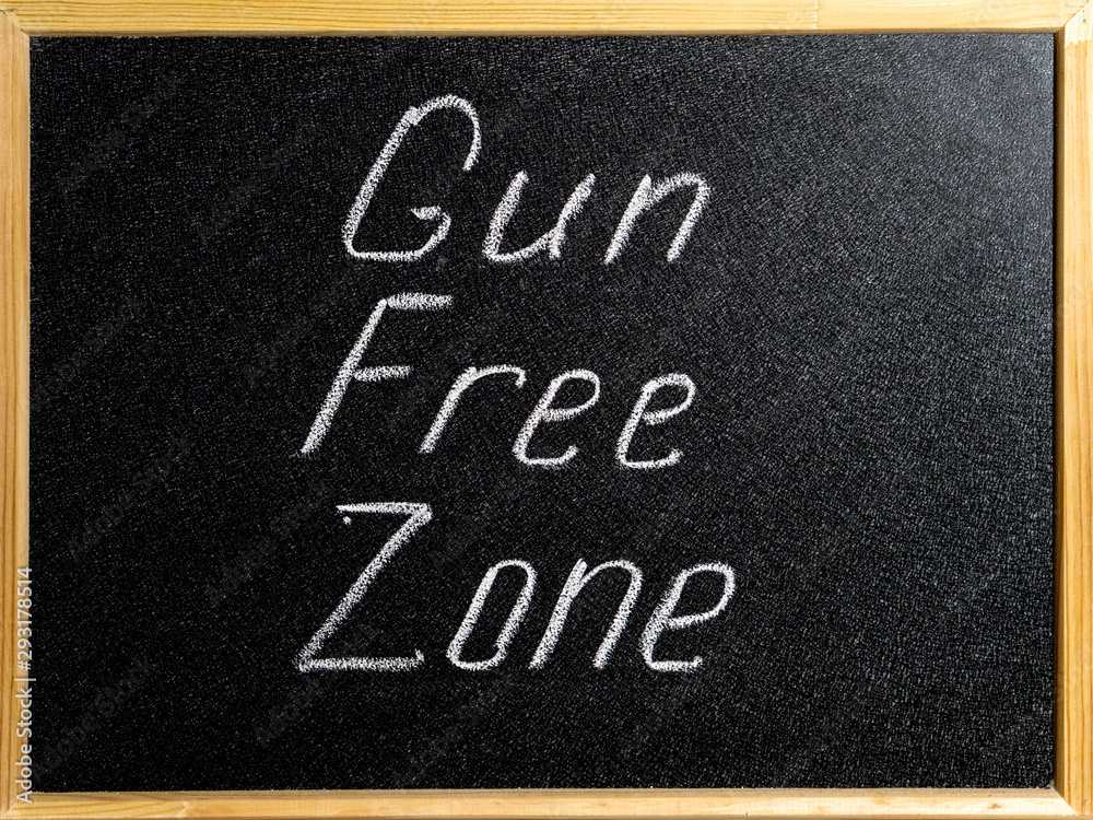 Fototapeta premium Inscription Gun Free Zone in chalk on a school blackboard