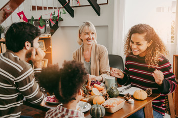 Thanksgiving Celebration Tradition Family Dinner Concept.family having holiday dinner and cutting turkey.Young black adult woman and her daughter happy..