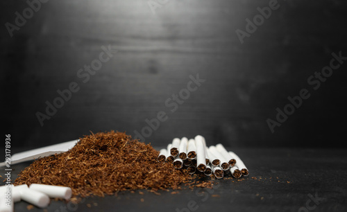 Raw tabaco on black wood background with copy space for text photo