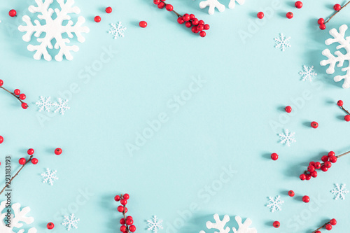 Christmas holiday composition. Xmas white decorations and red berries on pastel blue background. Christmas, New Year, winter concept. Flat lay, top view, copy space