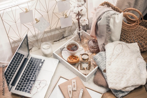 Toned photo. Autumn decor. A laptop, a mug of hot tea, a bun, candles. Cozy. Autumn.