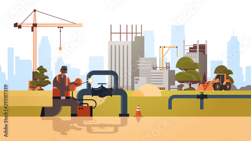 welder in protective mask welding big pipe steel pipelines workman in uniform building concept construction site background flat full length horizontal