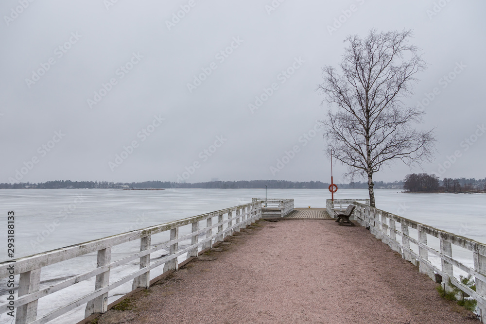 Small pier in Seurasaari island at cloudy, winter day, Finland.