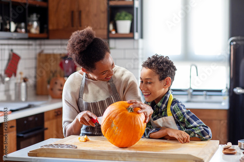 Woman with his son at the kitchen prepare pumpkin for halloween