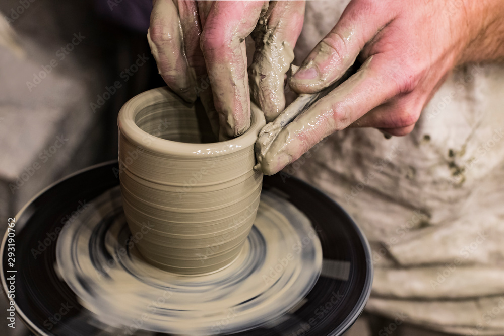 Hands of a potter make a handmade mug out of clay photo taken close-up Hands of a potter make a handmade mug out of clay photo taken close-up