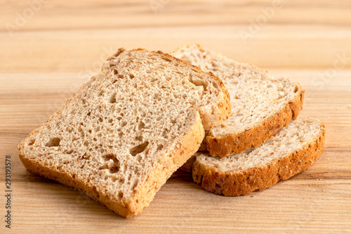 Fotografia Three slices of whole wheat toast bread isolated on light wood.