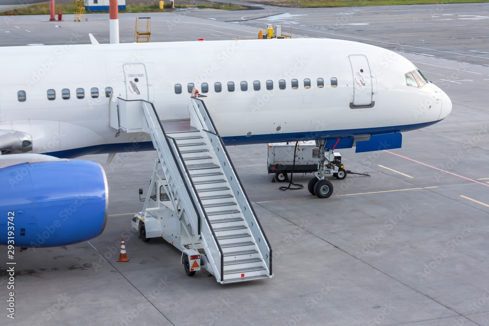 Aerial view the nose of the aircraft, ladder to the entrance of the aircraft in the parking at the airport. Aerial view the nose of the aircraft, ladder to the entrance of the aircraft in the parking at the airport.