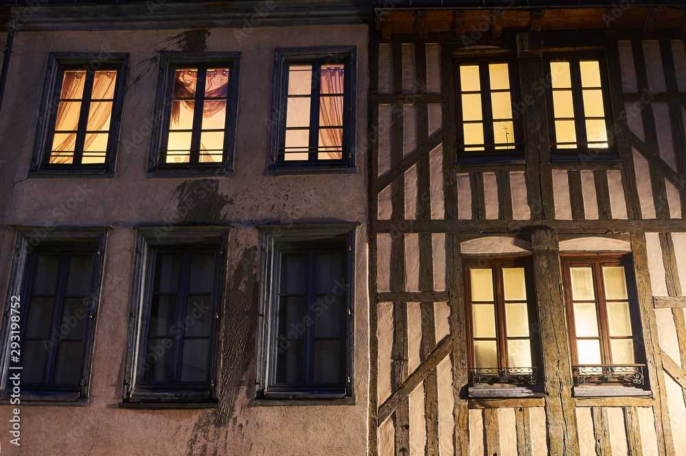 Windows of a historic house at night in the city of Troyes in France.