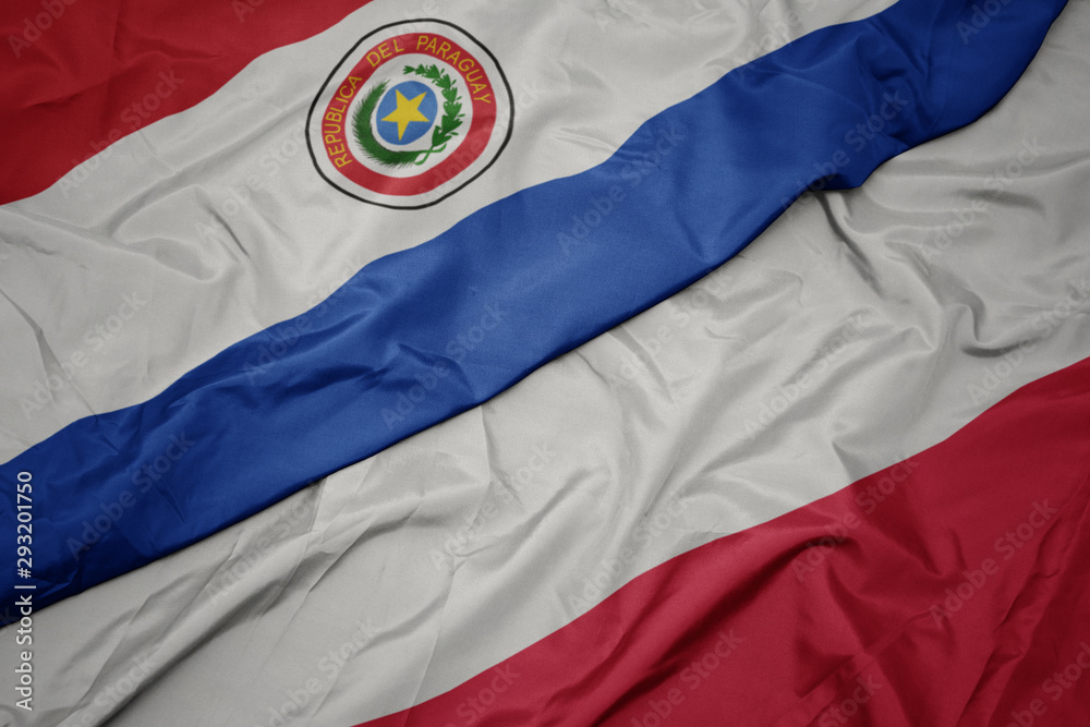 Fototapeta premium waving colorful flag of poland and national flag of paraguay.