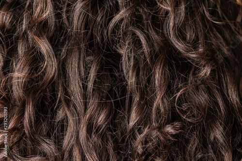 Canvas Print A close up and macro view on the dark brown hair of a girl with curly locks, filling the frame with detail creating a wavy textured pattern