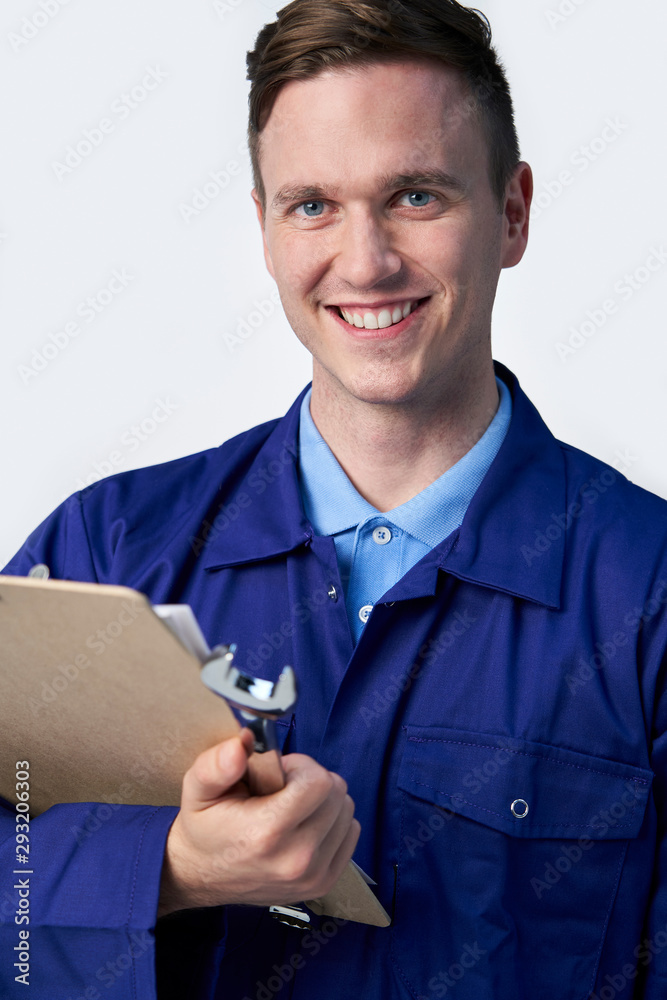 Studio Portrait Of Male Engineer With Clipboard And Spanner Against White Background Studio Portrait Of Male Engineer With Clipboard And Spanner Against White Background